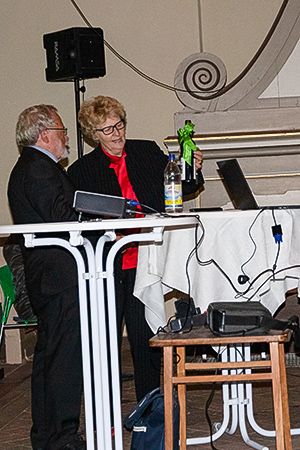 Mit einer Flasche Wein vom Zescher Weinberg bedankt sich Karola andrae bei Dr. Kaak